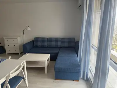 a living room with a blue couch and a table at Lora - Tsarevo in Tsarevo