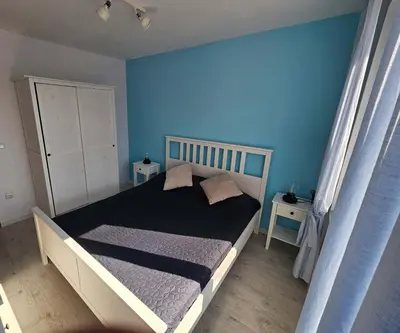 a bedroom with a bed with a blue wall at Lora - Tsarevo in Tsarevo