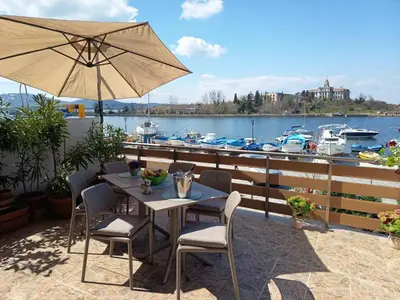 a table and chairs with an umbrella on a patio at Cozi 2BD Apartment with Sea View in the Old Town of Sozopol in Sozopol