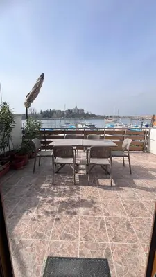 a patio with a table and chairs and a view of the water at Cozi 2BD Apartment with Sea View in the Old Town of Sozopol in Sozopol