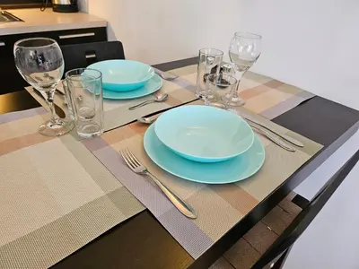 a table with plates and glasses on a table at Студио за нощувки в Сарафово in Burgas City
