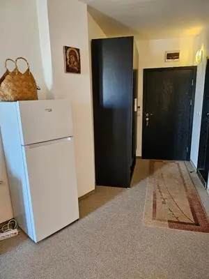 a room with a white refrigerator and a black door at Студио за гости на Сарафово in Burgas City