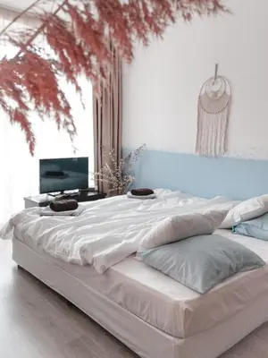 a bedroom with a large white bed with a blue headboard at Boho Studio 4 pools 10min to the beach in Burgas City