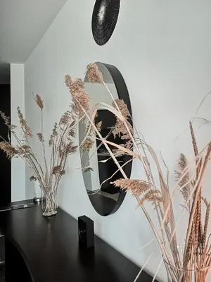 a mirror on a wall with plants on a table at Boho Studio 4 pools 10min to the beach in Burgas City