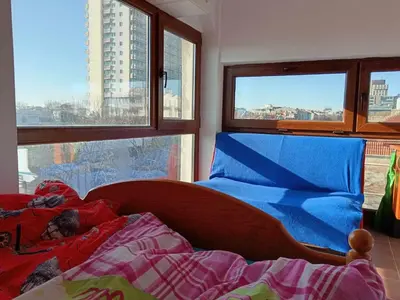 a bed in a room with a view of a city at На пъпа на Варна, голяма стая! in Varna City