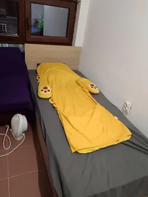 a yellow blanket is laying on a bed at На пъпа на Варна, голяма стая! in Varna City