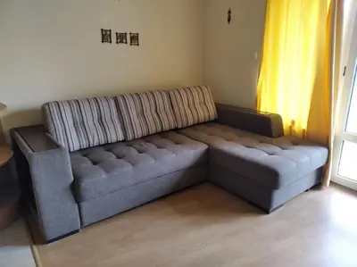 a couch sitting in a living room next to a window at Yassen Sunny Beach in Sunny Beach