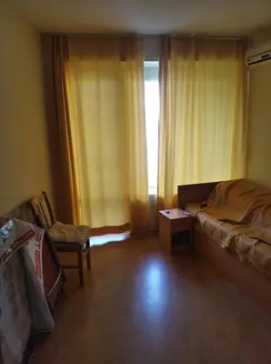 a bedroom with a bed and a chair and a window at Yassen Sunny Beach in Sunny Beach