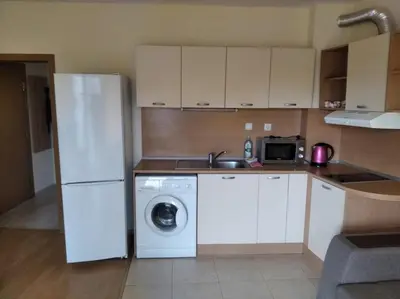 a kitchen with a white refrigerator and a washing machine at Yassen Sunny Beach in Sunny Beach