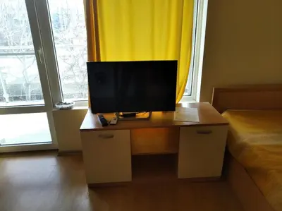 a television on a desk in a room with a window at Yassen Sunny Beach in Sunny Beach