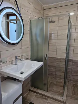 a bathroom with a shower and a sink and a mirror at Apart VILLA ITTA Sunny Beach in Sunny Beach