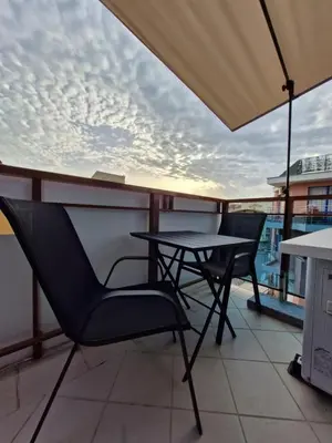 a balcony with a table and chairs on a roof at Apart VILLA ITTA Sunny Beach in Sunny Beach
