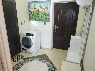 a washing machine in a room with a door at Апартамент на център Приморско in Primorsko