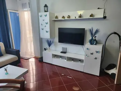 a living room with a television on a white entertainment center at Апартамент на център Приморско in Primorsko