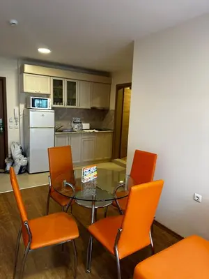 a kitchen with a glass table and orange chairs at Premier Fort Beach Hotel in Sveti Vlas