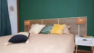 a bed with pillows on it in a bedroom at Апартамент Уютна почивка in Burgas City
