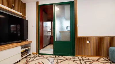 a green door in a living room with a television at Апартамент Уютна почивка in Burgas City