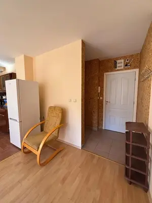 a living room with a chair and a refrigerator at Privilege First Line Sea in Elenite