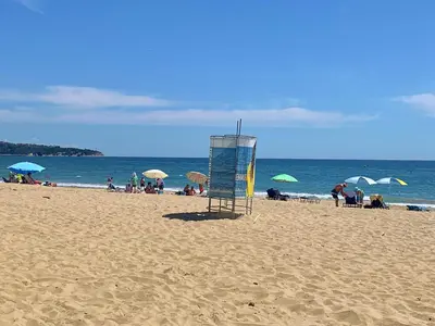 a lifeguard tower on a beach with people on the beach at Apartments Obzor Beach C - Апартаменти Обзор Бийч С in Obzor