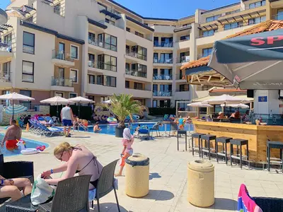 a group of people sitting around a pool at a resort at Apartments Obzor Beach C - Апартаменти Обзор Бийч С in Obzor
