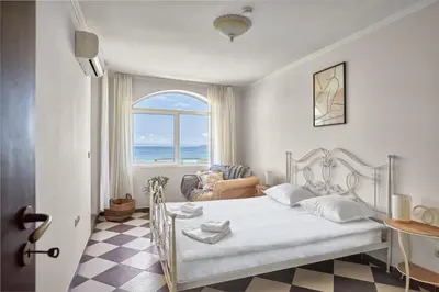 a bedroom with a bed with a view of the ocean at Beach Front Luxury Apartment in Sozopol