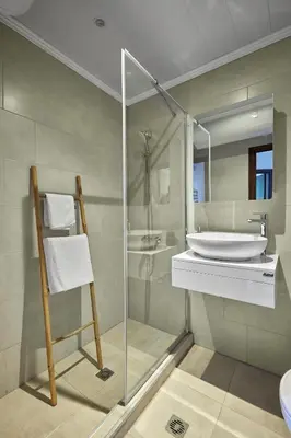 a bathroom with a glass shower and a sink at Beach Front Luxury Apartment in Sozopol