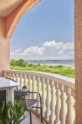 a balcony with a table and chairs and a view of the ocean at Beach Front Luxury Apartment in Sozopol