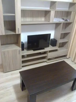 a living room with a entertainment center with a flat screen tv at Родина- Rey&Mar Apartment in Sveti Vlas
