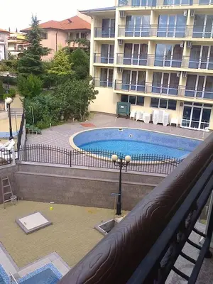 a swimming pool in front of a large building at Родина- Rey&Mar Apartment in Sveti Vlas
