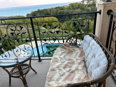 a bed on a balcony with a view of the ocean at Blue Bay Apartments in Byala