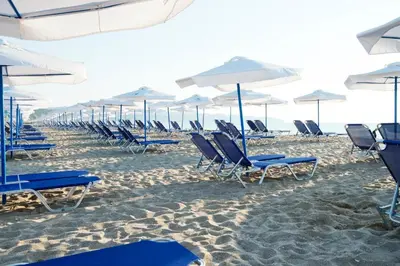 a group of chairs and umbrellas on a beach at Apartment Anna-Kalina in Obzor