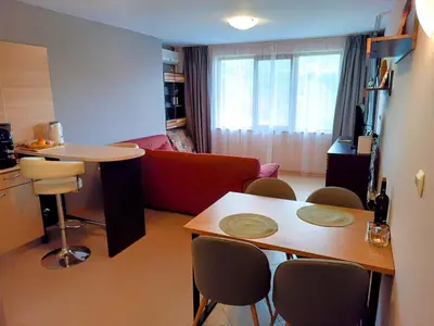 a living room with a couch and a table and chairs at Hills view apartment in Sunny Beach