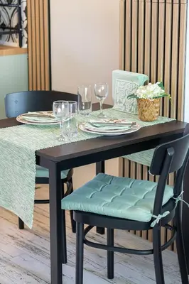 a dining room table with a blue chair and glasses at Green Dream Apart in Varna City