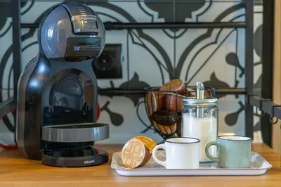 a coffee maker sitting on a table with two cups at Green Dream Apart in Varna City