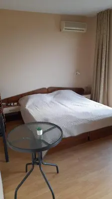 a small room with a bed and a glass table at Guest House Sveti Vlas in Sveti Vlas
