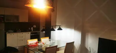 a kitchen with a table with chairs and a light at Nice 2 Bedroom Apartment with Sea and Poolview near Aheloy in Kableshkovo