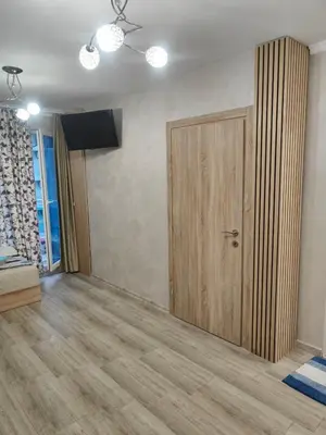 a room with a wooden door and a television at Лукс Апартамент Морска Перла in Primorsko