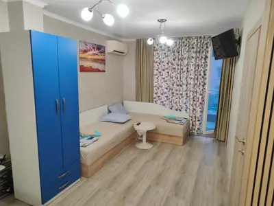 a small room with a bed and a window at Лукс Апартамент Морска Перла in Primorsko