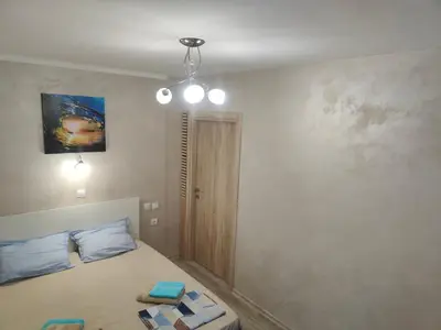 a bedroom with a bed with blue pillows on it at Лукс Апартамент Морска Перла in Primorsko