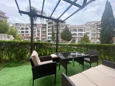 a patio with a table and chairs and a building at The Vineyard Spa&Resort Apartment with private garden near Aheloy in Kableshkovo