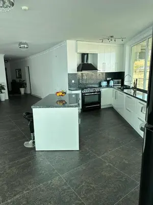 a large kitchen with white cabinets and a counter top at Beach Front Luxurious Two Bedroom Apartment in Byala