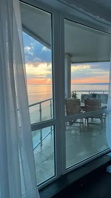 a balcony with a view of the ocean from a window at Beach Front Luxurious Two Bedroom Apartment in Byala