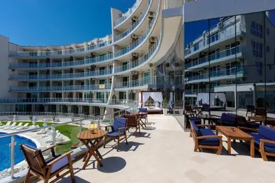 a large building with tables and chairs and a pool at Beach Front Luxurious Two Bedroom Apartment in Byala