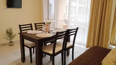 a dining room table and chairs in a living room at Апартамент в непосредствена близост до плажа in Burgas City