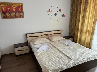 a bedroom with a bed with white sheets and pillows at Апартамент Emilia in Ravda