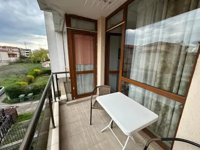 a white bench on the balcony of a house at Апартамент Emilia in Ravda