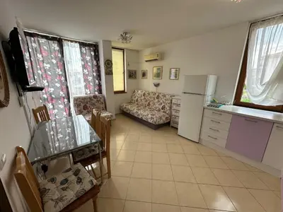 a kitchen and living room with a couch and a table at Апартамент Emilia in Ravda