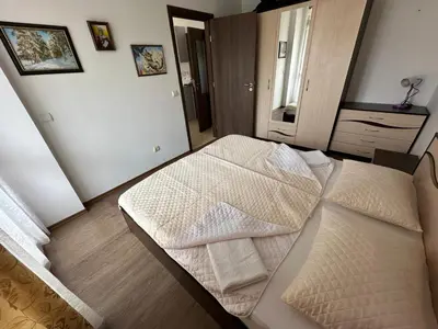 a bedroom with two beds with white sheets at Апартамент Emilia in Ravda