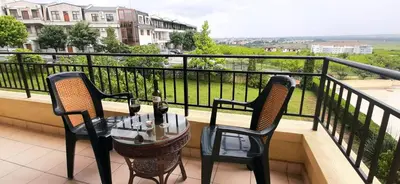 a balcony with two chairs and a table with wine glasses at Nessebar Apartment Pablo in Sunny Beach