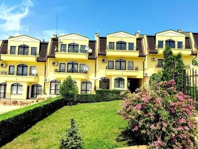 a large yellow building with a lawn in front of it at Nessebar Apartment Pablo in Sunny Beach